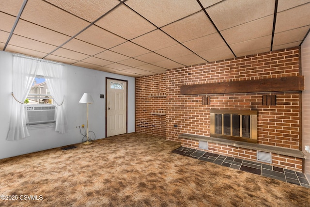1205 N River Ave, Sunbury, PA 17801 - unfurnished living room featuring a drop ceiling, cooling unit, a brick fireplace, carpet, and brick wall