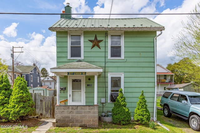 1205 N River Ave, Sunbury, PA 17801 - view of front facade featuring fence, metal roof, and a chimney