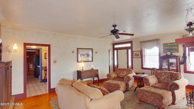 living area with light wood-style flooring and a ceiling fan