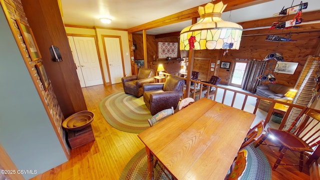 dining space with wooden walls and wood finished floors