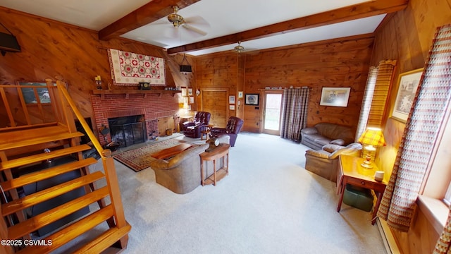 carpeted living area featuring beamed ceiling, wooden walls, ceiling fan, and a brick fireplace