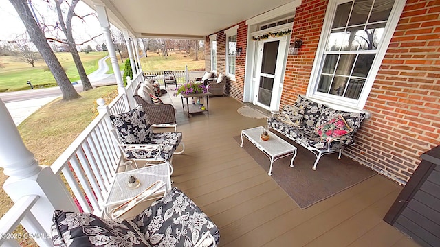 wooden terrace with covered porch and view of golf course