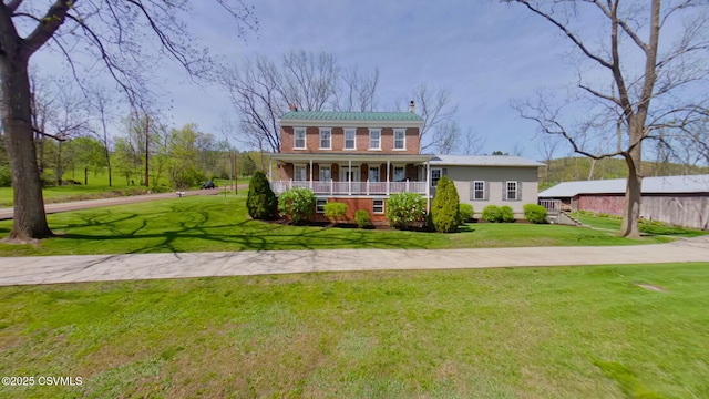 view of front facade with a chimney, covered porch, and a front lawn