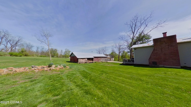 view of green lawn featuring an outdoor structure