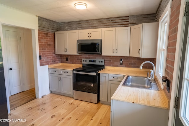 302 Walnut St, Selinsgrove, PA 17870 - kitchen featuring wood counters, light wood-style flooring, a sink, appliances with stainless steel finishes, and backsplash