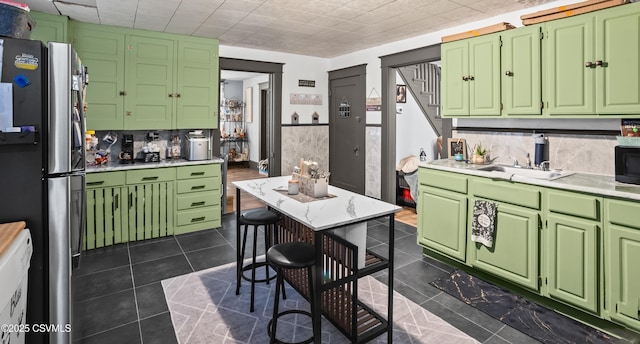 kitchen featuring dark tile patterned floors, black microwave, light countertops, and freestanding refrigerator