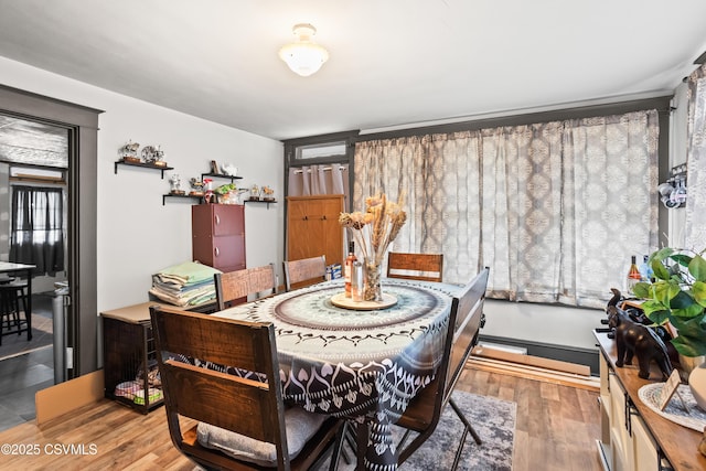dining area featuring wood finished floors and a baseboard radiator