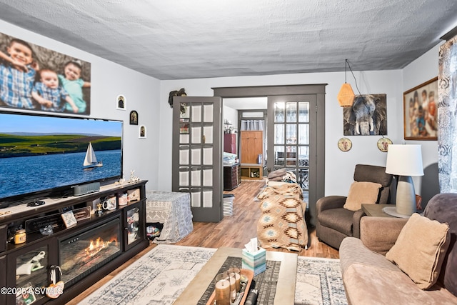 living room featuring a textured ceiling, wood finished floors, and french doors