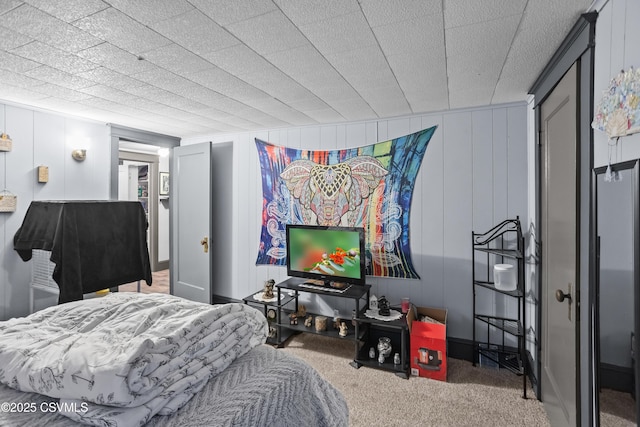 carpeted bedroom featuring a decorative wall