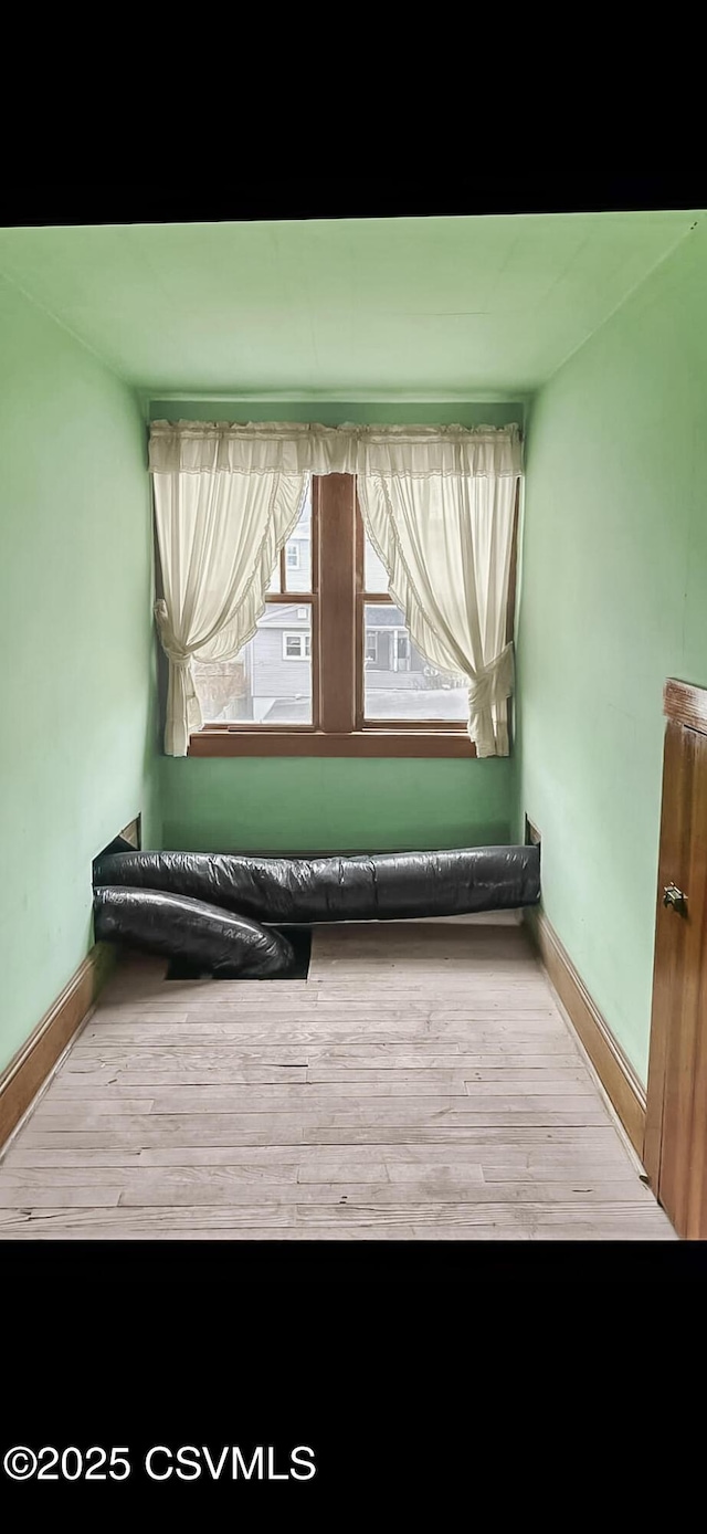 interior space with wood finished floors and baseboards