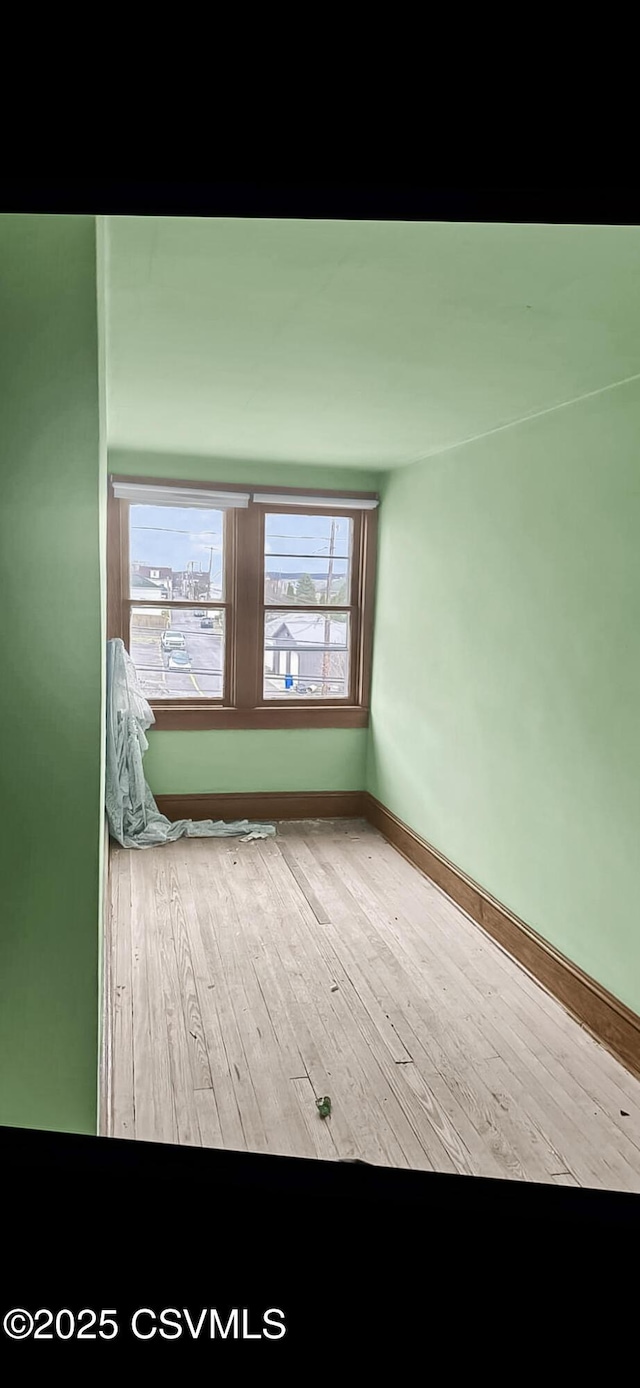 empty room with baseboards and hardwood / wood-style flooring