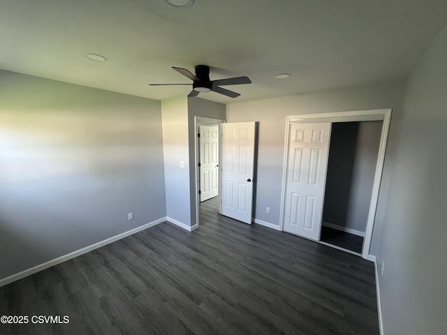 unfurnished bedroom with baseboards, ceiling fan, a closet, and dark wood-style floors