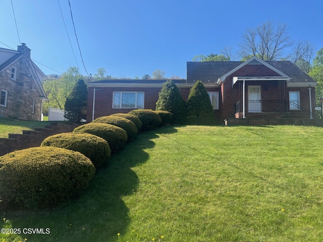 ranch-style home with brick siding and a front yard