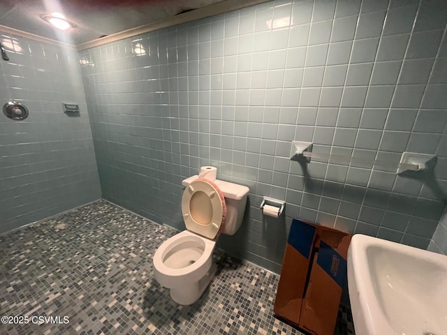 full bathroom with a sink, tile patterned floors, toilet, and tiled shower