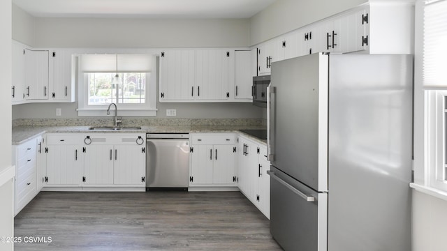 kitchen featuring a sink, appliances with stainless steel finishes, white cabinetry, and dark wood-type flooring