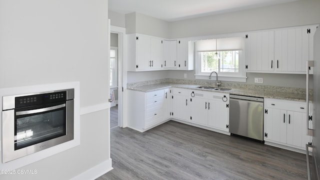 kitchen featuring stainless steel appliances, dark wood finished floors, white cabinetry, and a sink