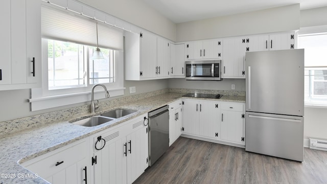 kitchen with a sink, appliances with stainless steel finishes, plenty of natural light, and dark wood-type flooring