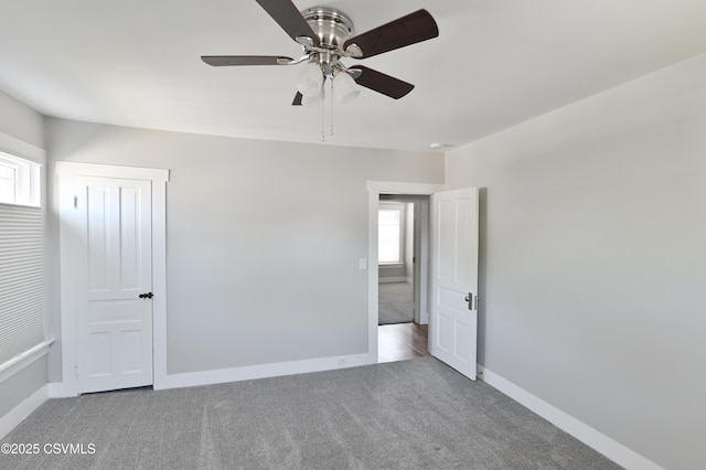 unfurnished bedroom featuring baseboards, multiple windows, and carpet flooring