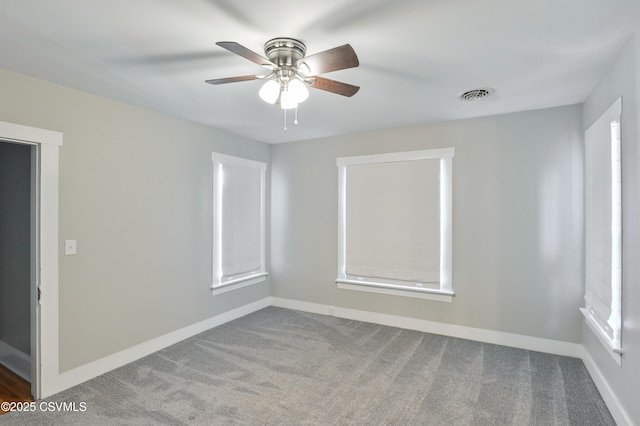 unfurnished room featuring carpet flooring, ceiling fan, visible vents, and baseboards