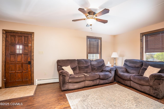 living room featuring a ceiling fan, light wood finished floors, and baseboard heating