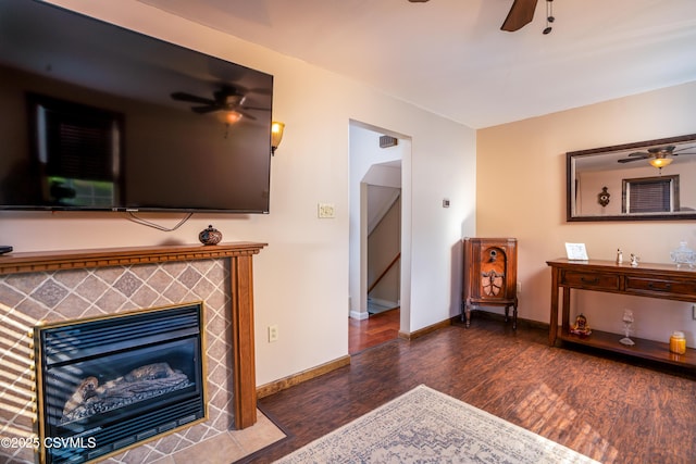 living room with baseboards, ceiling fan, and wood finished floors