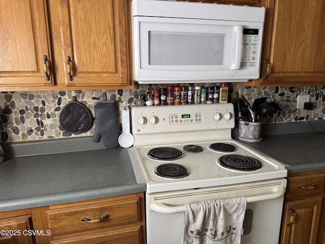 kitchen featuring brown cabinets, backsplash, and white appliances