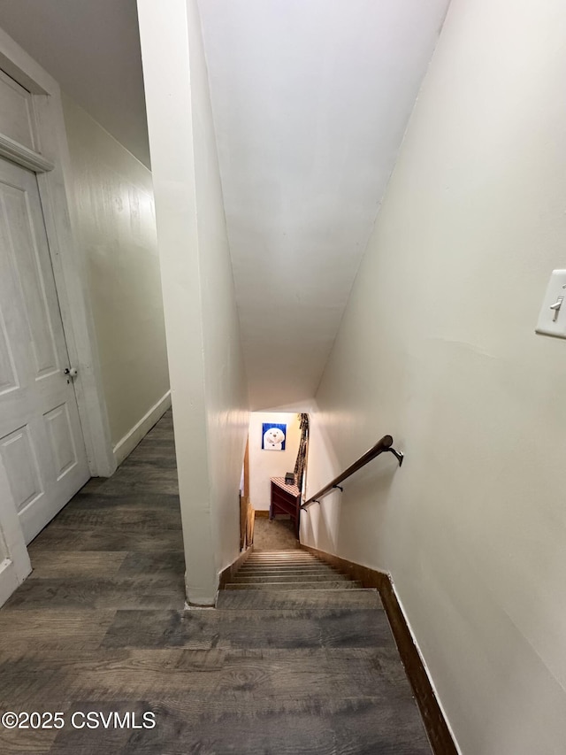 staircase featuring baseboards and wood finished floors