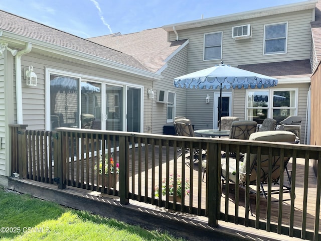rear view of house featuring a deck and roof with shingles