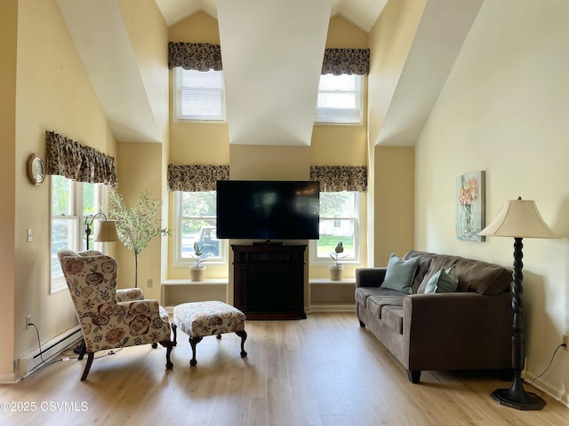 living room featuring high vaulted ceiling, baseboard heating, wood finished floors, and a wealth of natural light