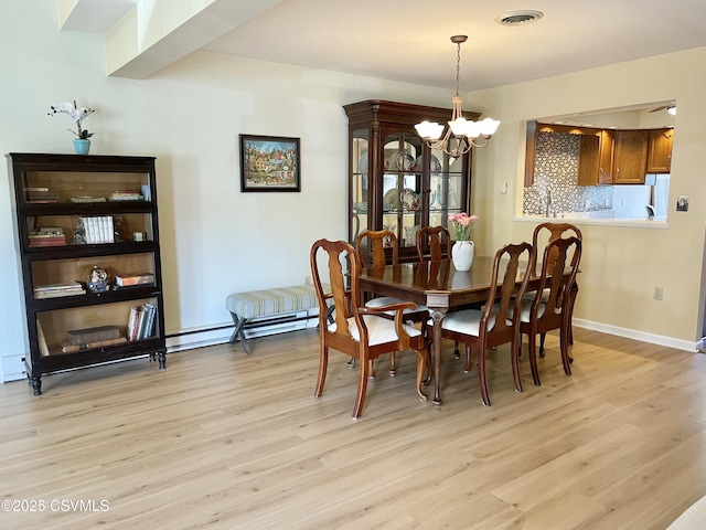 dining room featuring visible vents, baseboards, an inviting chandelier, and light wood finished floors