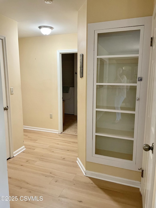 hallway featuring baseboards and wood finished floors