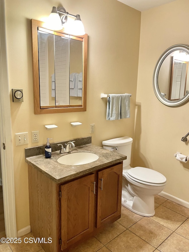 bathroom with toilet, baseboards, tile patterned flooring, and vanity