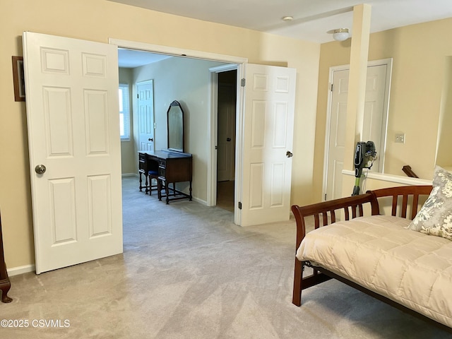 bedroom featuring baseboards and light colored carpet