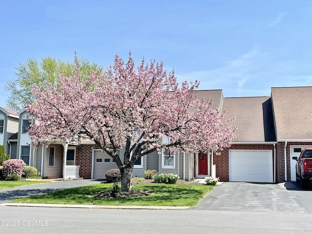 view of front of house with a garage, driveway, and brick siding