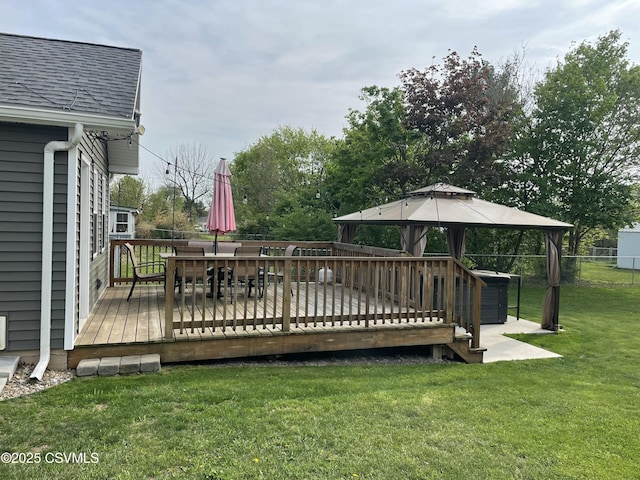 wooden terrace with a lawn, a gazebo, fence, and outdoor dining area