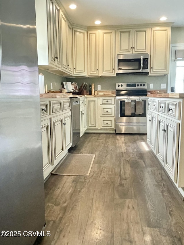kitchen featuring recessed lighting, cream cabinets, stainless steel appliances, and dark wood finished floors