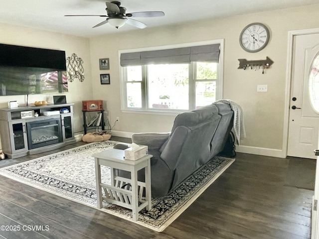 living area with baseboards, ceiling fan, and wood finished floors