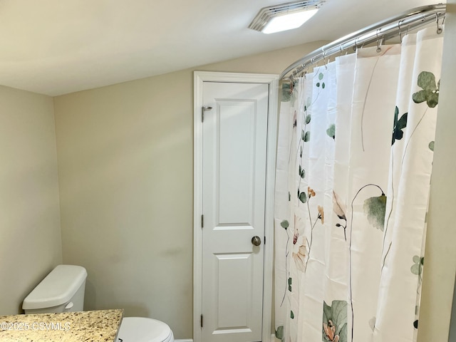 bathroom featuring toilet, a shower with shower curtain, and vanity