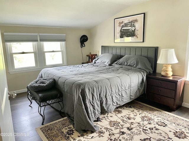 bedroom with baseboards, wood finished floors, and lofted ceiling