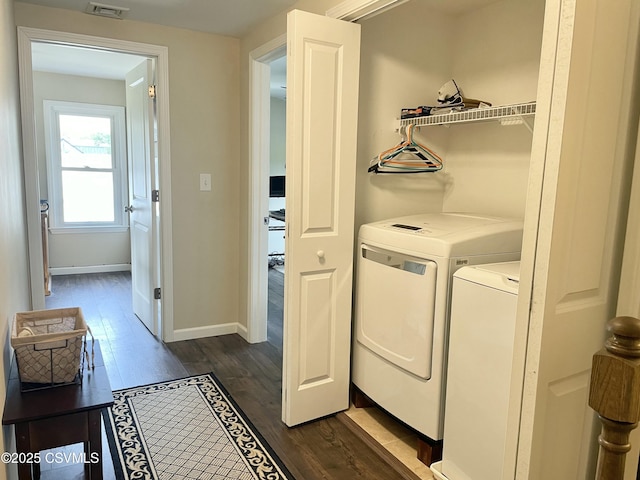 laundry area with laundry area, visible vents, dark wood finished floors, baseboards, and separate washer and dryer