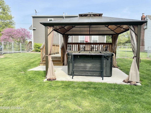 exterior space featuring a fenced backyard, a gazebo, and a hot tub
