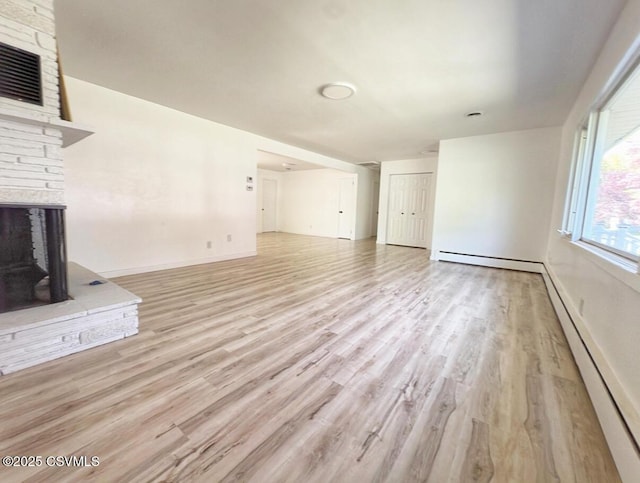 125 Knights Dr, Bloomsburg, PA 17815 - unfurnished living room featuring light wood-style floors, a fireplace, a baseboard heating unit, and visible vents