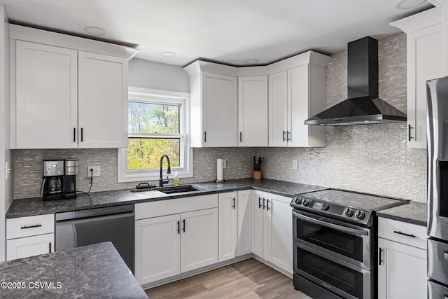31 Holly Ct, Danville, PA 17821 - kitchen featuring a sink, stainless steel appliances, wall chimney range hood, light wood-style flooring, and white cabinetry
