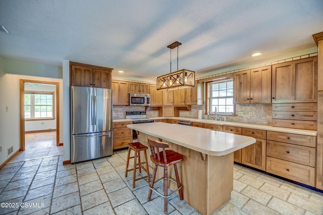 kitchen featuring stainless steel appliances, tasteful backsplash, light countertops, plenty of natural light, and recessed lighting