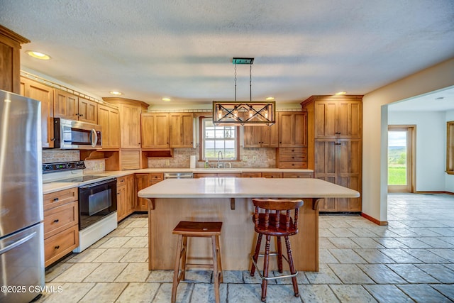 kitchen featuring stainless steel appliances, light countertops, decorative backsplash, a center island, and recessed lighting