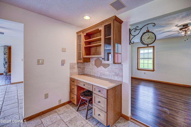 office space with a textured ceiling, baseboards, ceiling fan, recessed lighting, and built in study area