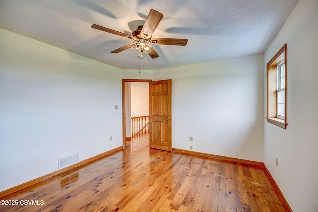 spare room with a ceiling fan, baseboards, and light wood-style flooring