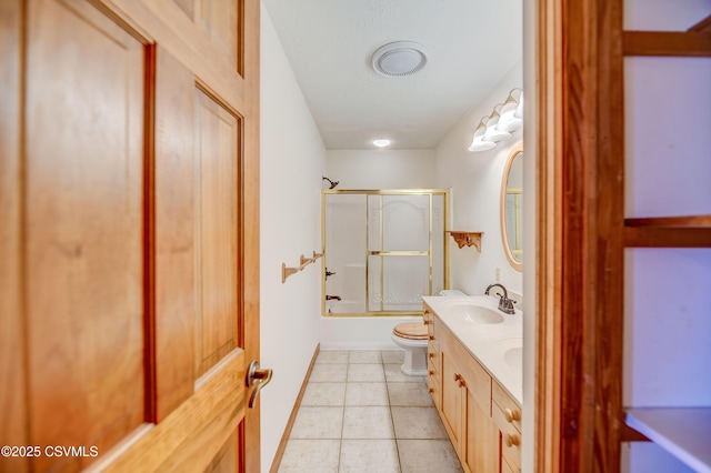 bathroom with toilet, tile patterned floors, vanity, and bath / shower combo with glass door