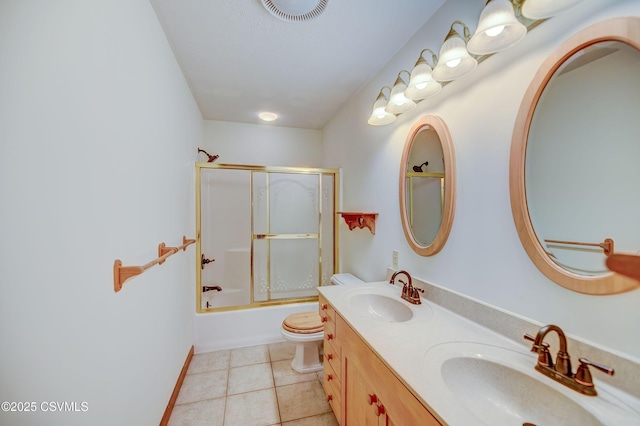 full bath with tile patterned flooring, double vanity, toilet, and combined bath / shower with glass door