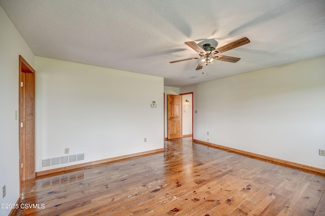 spare room with a ceiling fan, wood-type flooring, and baseboards